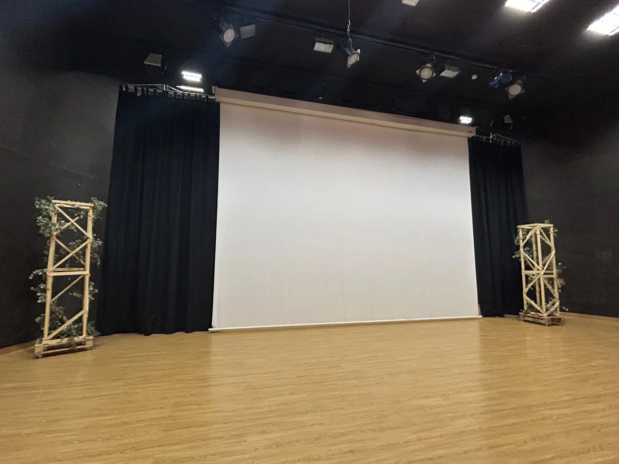 Escenario con pantalla de proyección y suelo de parqué